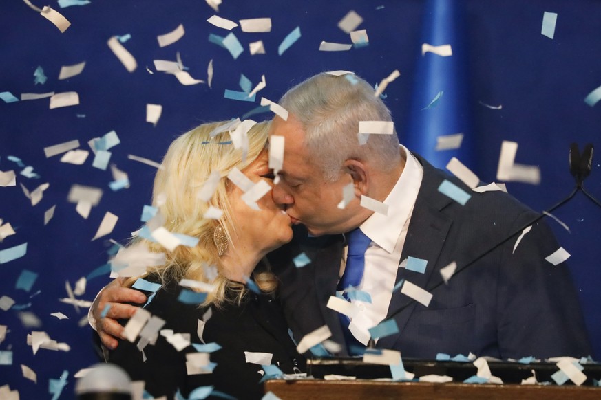 Israeli Prime Minister Benjamin Netanyahu kisses his wife Sara after first exit poll results for the Israeli elections at his party&#039;s headquarters in Tel Aviv, Israel, Monday, Feb. 2, 2020. (AP P ...