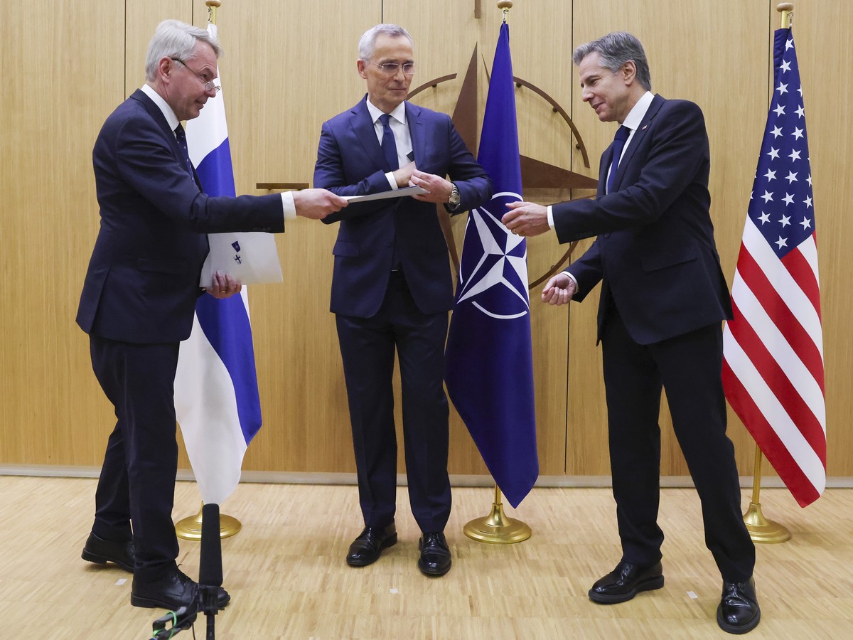 Finnish Foreign Minister Pekka Haavisto, left, hands over his nation's accession document to United States Secretary of State Antony Blinken, right, during a meeting of NATO foreign ministers at  ...