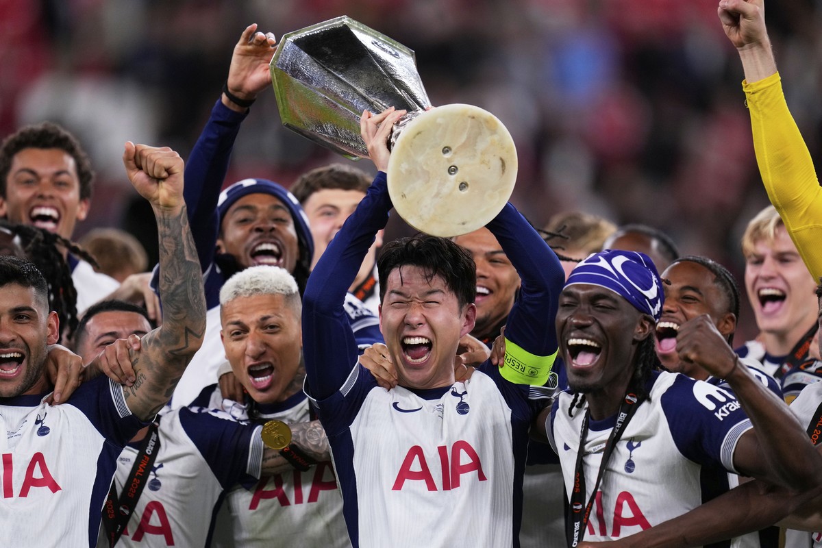 Tottenham's Son Heung-min holds the trophy aloft as he celebrates with teammates after winning the Europa League final soccer match against Manchester United at the San Mames Stadium in Bilbao, S ...