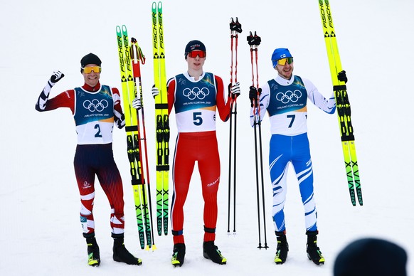 epa12749653 (L-R) Silver medalist Johannes Lamparter of Austria, gold medalist Jens Luraas Oftebro of Norway and bronze medalist Ilkka Herola of Finland pose in the finish area during the Men's I ...
