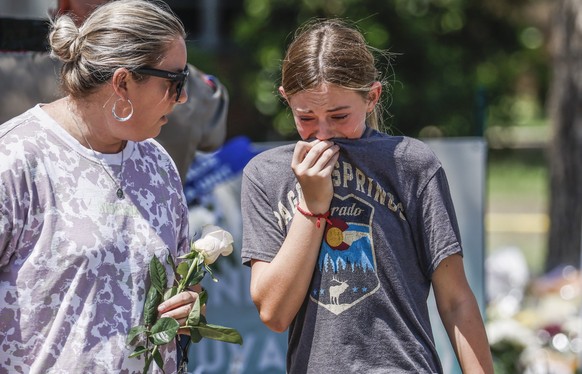epa09982669 A girl (R) cries as he leaves after placing flowers at a memorial to victims following the mass shooting at the Robb Elementary School in Uvalde, Texas, USA, 28 May 2022. According to Texa ...