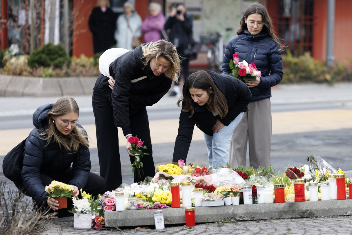 People lay flowers at the site where a postal bus caught fire in the center of Kerzers, Switzerland, Wednesday, March 11, 2026. According to the Fribourg cantonal police, six people died and five othe ...