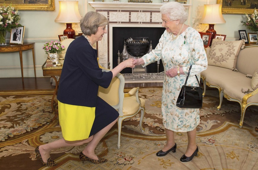 CORRECTS DATE OF THE FILE PHOTO FILE - This is a July 13, 2016 file photo of Queen Elizabeth II as she welcoming Theresa May at the start of an audience in Buckingham Palace, London, where she invited ...
