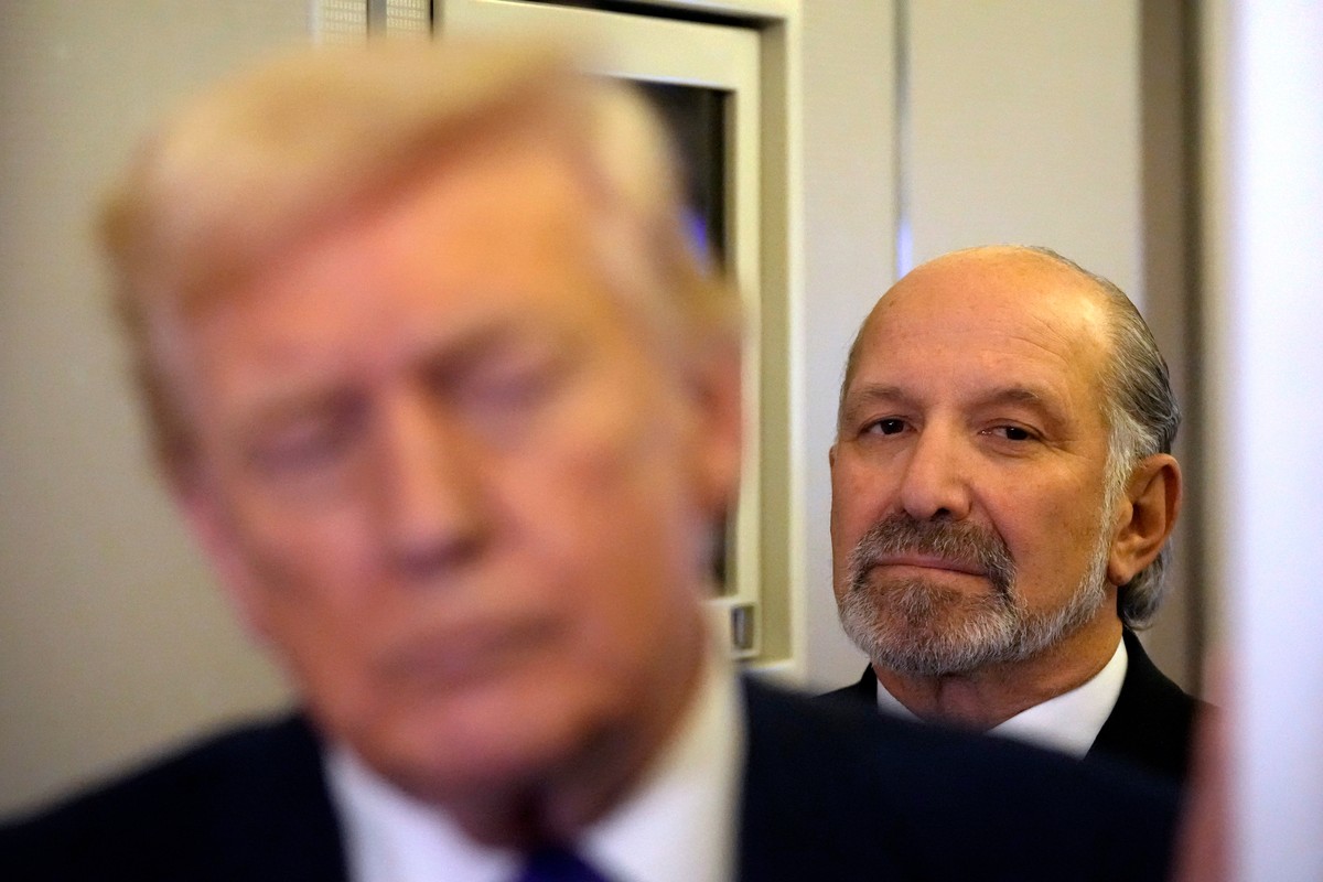Commerce Secretary Howard Lutnick listens as President Donald Trump speaks to reporters as he flies aboard Air Force One from Joint Base Andrews, Md., to West Palm Beach, Fla., Friday, Feb. 6, 2026 (A ...