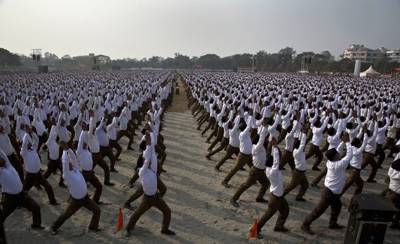 Volunteers of Hindu nationalist Rashtriya Swayamsevak Sangh (RSS), or the National Volunteers Force, perform yoga together during a mass public rally in Gauhati, India, Sunday, Jan. 21, 2018. Accordin ...