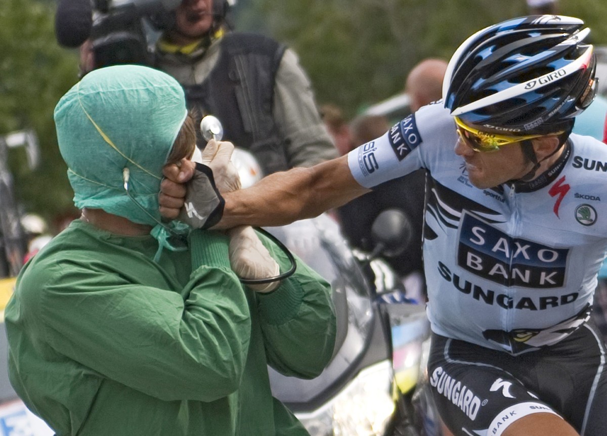 epa02836745 Saxo Bank Sungard team rider Alberto Contador of Spain punches a spectator who was running alongside him during the 19th stage of the Tour de France cycling race between Modane and Alpe-d& ...
