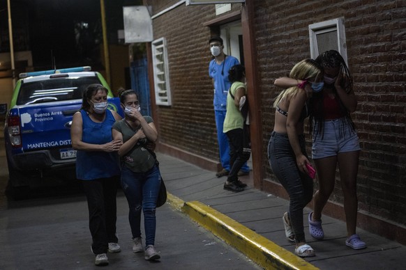 Relatives and friends of people who were poisoned with adulterated cocaine cry after talking to doctors outside the emergency room of a hospital in the outskirts of Buenos Aires, Argentina, Wednesday, ...