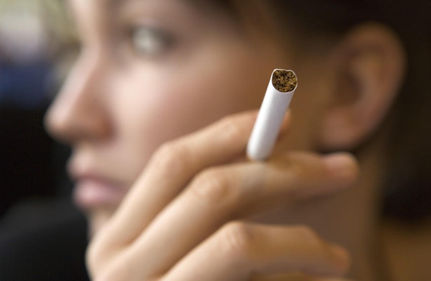 ARCHIVBILD ZUR MK DER SUCHTVERBAENDE UEBER DIE SCHWEIZER TABAKPOLITIK, AM DIENSTAG, 21. NOVEMBER 2017 - A young woman smokes a cigarette after having had lunch at the restaurant Toto in Zurich, Switze ...