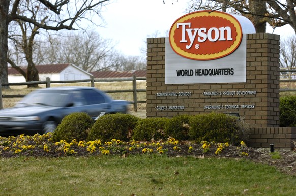 FILE - In this Jan. 29, 2006, file photo, a car passes in front of a sign at Tyson headquarters in Springdale, Ark. The union representing workers at poultry processing plants sued the federal governm ...