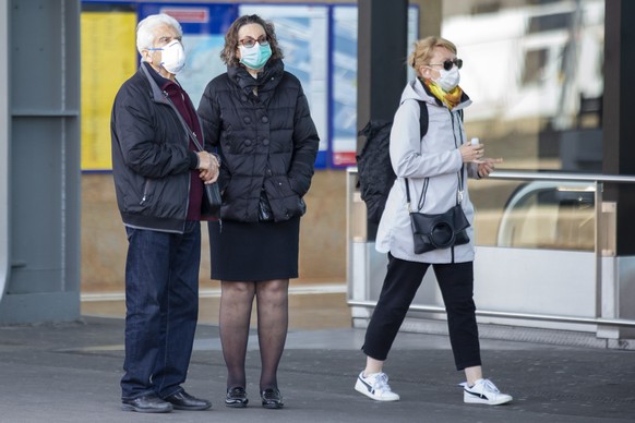 epa08298105 Persons wearing protective face masks as a precaution against the spread of the coronavirus COVID-19 wait their train at the railway station of Cornavin, in Geneva, Switzerland, 16 March 2 ...