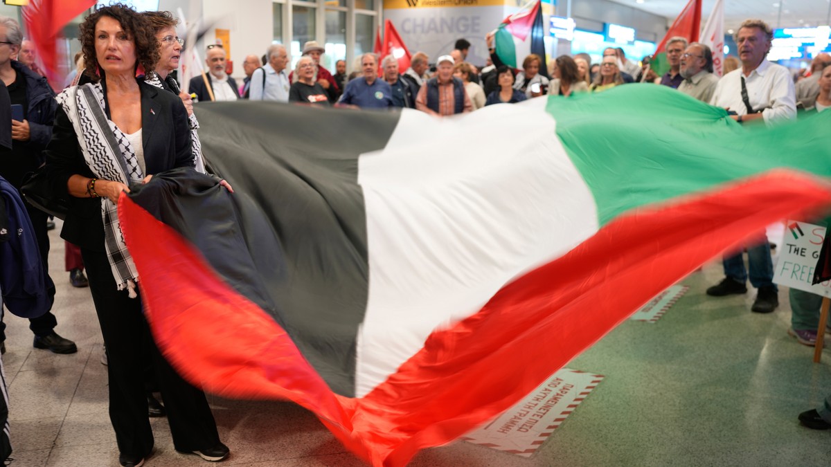 Pro-Palestinians protesters wait for Swedish activist Greta Thunberg to arrive at the Eleftherios Venizelos International Airport in Athens, Monday, Oct. 6, 2025 after being deported from Israel for t ...