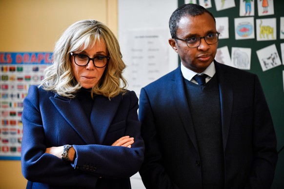 epa10363518 First Lady of France Brigitte Macron (L) and French Minister of Education and Youth Pap Ndiaye visit a classroom at a primary school for foreign language students in Paris, France, December 13 ...