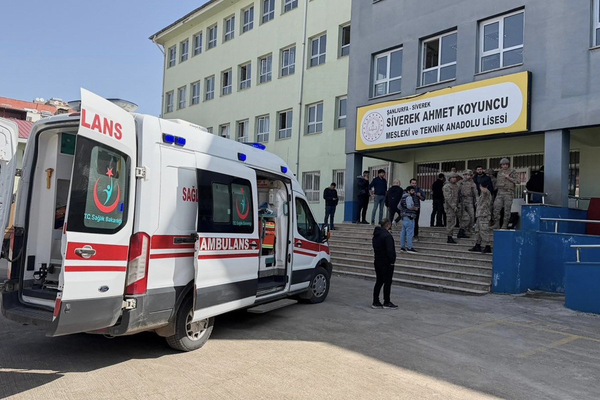 Turkish security forces and emergency staff stand at the courtyard of a high school where an assailant opened fire, in Siverek, south east Turkey, Tuesday, April 14, 2026, (Mevlut Bayraktar/IHA via AP ...