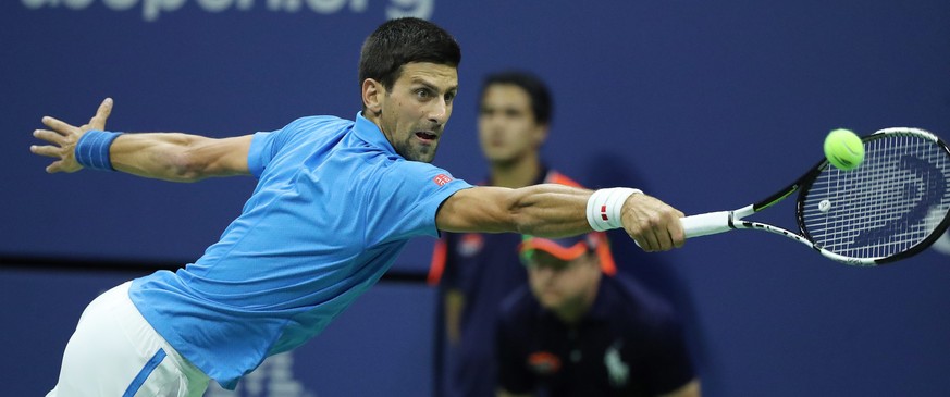 epa05527963 Novak Sjokovic of Serbia hits a return to Jo-Wilfried Tsonga of France during their quarterfinals round match on the ninth day of the US Open Tennis Championships at the USTA National Tenn ...