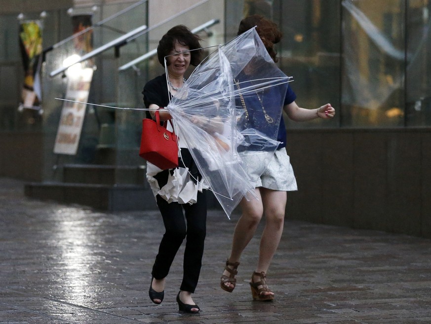 Schlimmer war es im Westen: In Tokyo kämpfen Passantinnen nur mit ihren Regenschrimen.