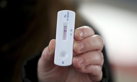 A man shows a negative COVID-19 test in a set up for rapid new coronavirus testing in Vienna, Austria, Monday, Nov. 30, 2020. The Austrian government has moved to restrict freedom of movement for peop ...