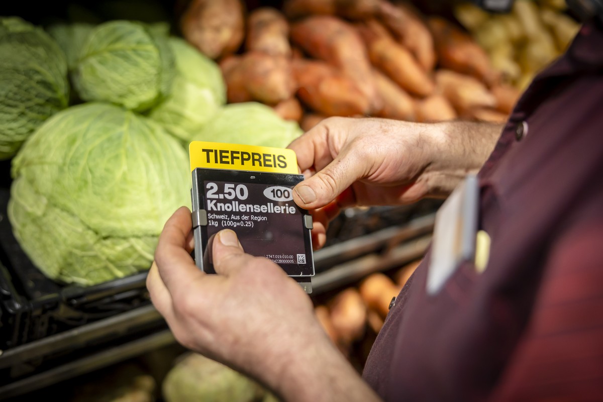 Ein Mitarbeiter bringt ein Schild mit der Aufschrift "Tiefpreis" beim Gemuese in der Migros Limmatplatz an, aufgenommen anlaesslich einer Medienkonferenz zu Neuerungen in den Migros-Supermae ...
