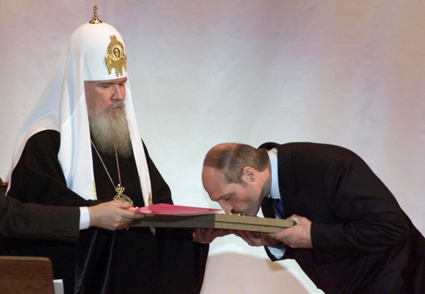 Belarus&#039; President Alexander Lukashenko kisses the award received from Russian Orthodox Patriarch Alexy II, left, in the Christ the Savior Cathedral in Moscow, Tuesday, Jan. 23, 2001. The award,  ...