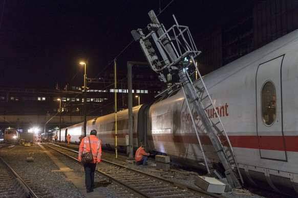 epa06358158 Railworkers inspect a ICE train of German Deutsche Bahn traveling from Hamburg to Zurich, after it derailed at the entry to the Basel train station, in Basel, Switzerland, 29 November 2017 ...