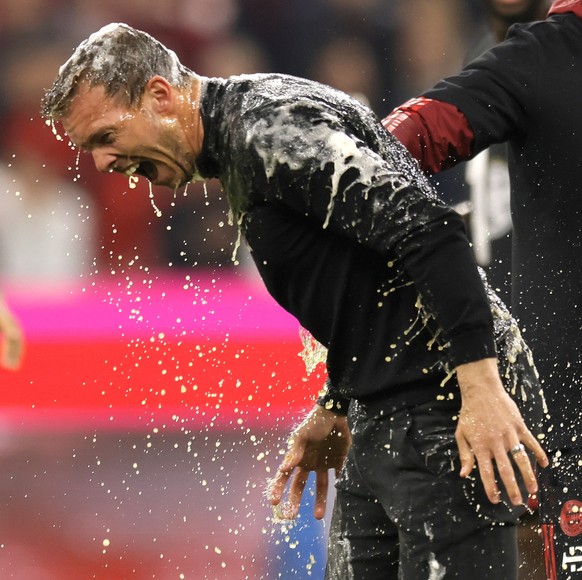 epa09904949 Bayern&#039;s head coach Julian Nagelsmann (L) receives a beer shower from Bayern Munich&#039;s assistant coach Holger Broich (R) celebrating the tenth consecutive Bundesliga title, after  ...