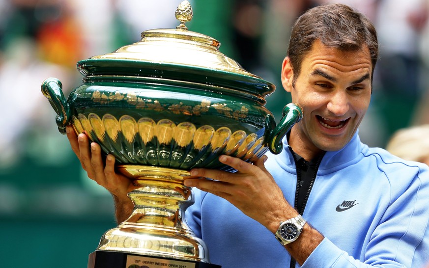 epa06049485 Roger Federer of Switzerland poses with his trophy after defeating Alexander Zverev of Germany in their final match of the ATP tennis tournament in Halle, Germany, 25 June 2017. EPA/TYLER  ...