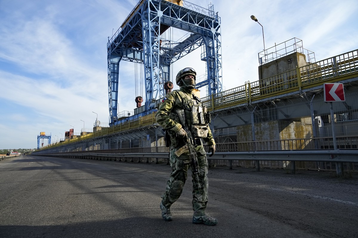 FILE - A Russian soldier patrols an area at the Kakhovka Hydroelectric Station, a run-of-river power plant on the Dnieper River in Kherson region, south Ukraine, on May 20, 2022. Even as the Russian w ...