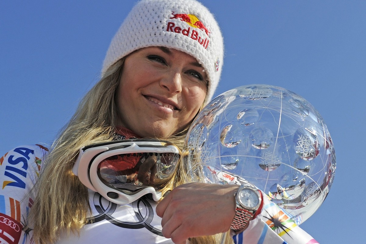 Lindsey Vonn of the US celebrates in the finish area holding the crystal globe of the winner of the Overall standing at the Alpine Ski World Cup finals, in Schladming, Austria, Sunday, March 18, 2012. ...