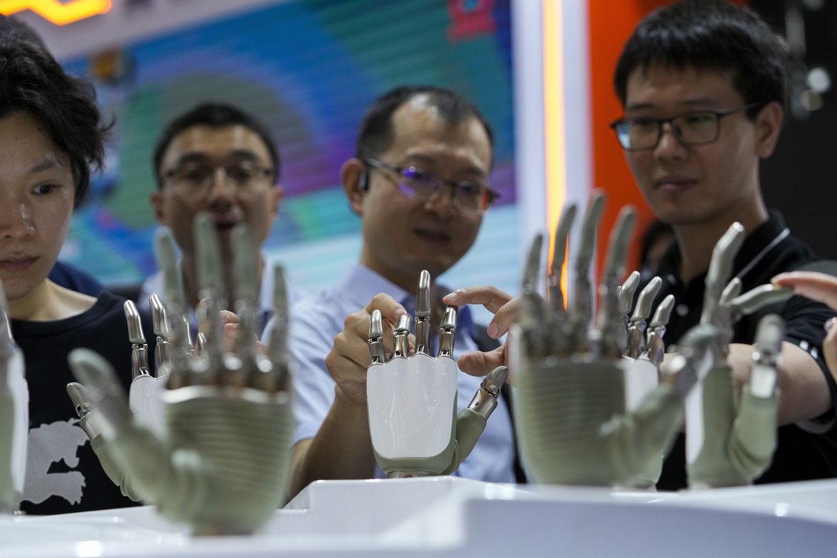 Visitors touch the humanoid robot hands on display at an AI exhibition booth during the 2024 The World Artificial Intelligence Conference (WAIC) &amp; High-Level Meeting on Global AI Governance with t ...