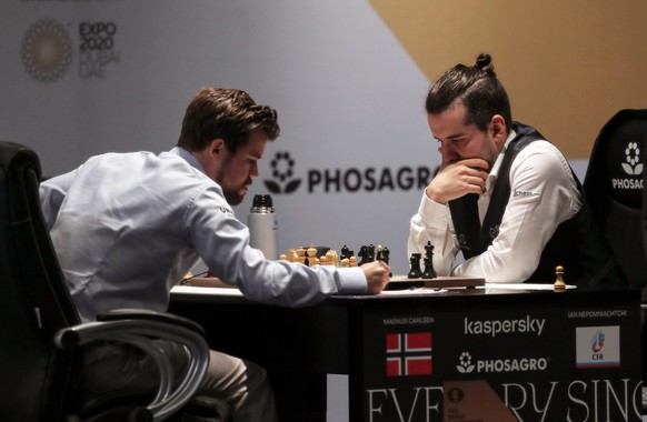 epa09607014 Defending Champion Magnus Carlsen of Norway (L) plays against Ian Nepomniachtchi of Russia during the second round of FIDE World Chess Championship during the EXPO 2020 Dubai in Dubai, United Arab Emirates, 27 November 2021. EPA/ALI HAIDER