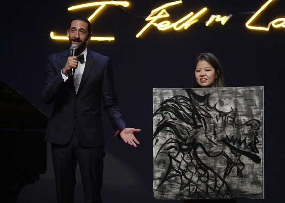 US actor Adrien Brody, left, donates his painting for auction at the fundraising gala organized by amfAR (The Foundation for AIDS Research) in Hong Kong, Saturday, March 19, 2016. (AP Photo/Kin Cheung ...