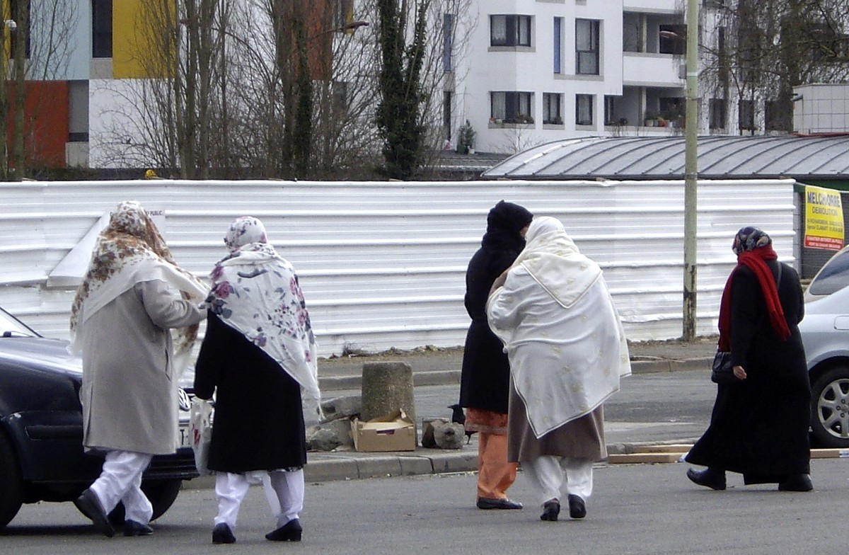 FILE - In this Feb. 7, 2013 file photo, women walk in the streets of Montfermeil, outside Paris. French Prime Minister Manuel Valls shocked many this week by referring to a "territorial, social,  ...