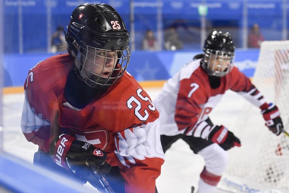 Alina Muller of Switzerland, left, fights for the puck with Mika Hori of Japan, during the women ice hockey classification match between Japan and Switzerland in the Kwandong Hockey Centre during the  ...