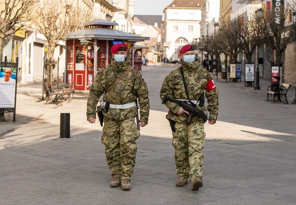 epa08314740 Military persons patrol in downtown of Gyor, Hungary, 23 March 2020. The patrol is deployed to keep up public safety and order during the time of the pandemic novel coronavirus. Countries  ...