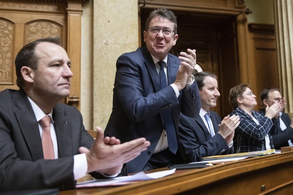 Die SVP- Nationalraete Thomas Matter, ZH, Albert Roesti, BE, und Thomas Aeschi, ZG, von links, applaudieren waehrend den Bundesratswahlen, am Mittwoch, 11. Dezember 2019, in Bern. (KEYSTONE/Peter Klau ...