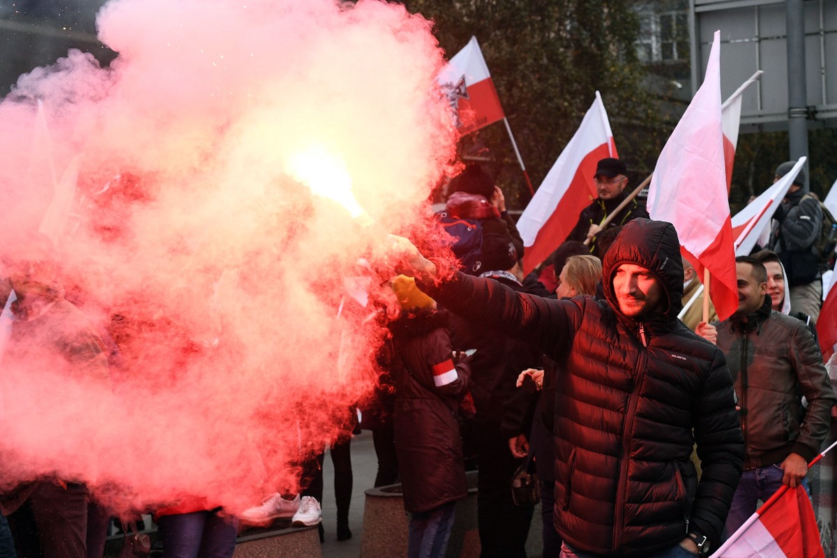 epa07158250 People light flares as they gather in the city center to take part in the National White and Red March 'For You Poland' to mark Polish Independence Day in Warsaw, Poland, 11 Nove ...