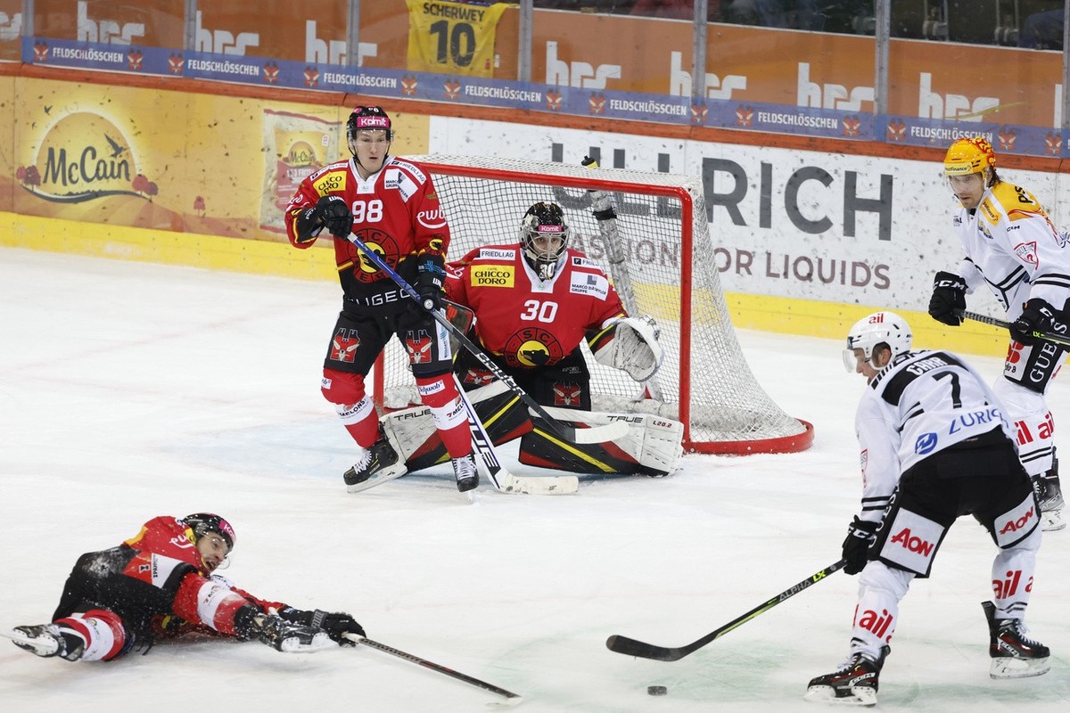 Berns Romain Loeffel, Berns Benjamin Baumgartner, Berns Torhueter Philip Wuethrich, Luganos Daniel Carr und Luganos PostFinance Topscorer Markus Granlund, von links, in Aktion, im Eishockey Meistersch ...