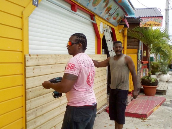 Men board up buildings ahead of Hurricane Maria in Sainte-Anne on the French Caribbean island of Guadeloupe, Monday, Sept. 18, 2017. Hurricane Maria grew into a Category 3 storm on Monday as it barrel ...