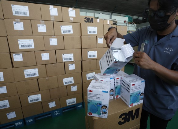 epa08355322 A worker displays N95 face masks destined to medical personnel in the country, at a warehouse of the Government Pharmaceutical Organization (GPO) in Bangkok, Thailand, 10 April 2020. The G ...