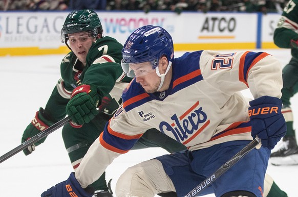 Minnesota Wild's Brock Faber (7) tries to stop Edmonton Oilers' Curtis Lazar (20) during second period NHL action, in Edmonton on Saturday, Jan. 31, 2026. (Jason Franson/The Canadian Press v ...