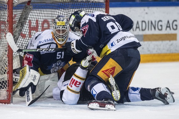 Zugs Torhueter Tobias Stephan, Luganos Julian Walker und Zugs Sven Senteler, von links, im ersten Eishockey Playoff-Viertelfinalspiel der National League zwischen dem EV Zug und dem HC Lugano am Samst ...