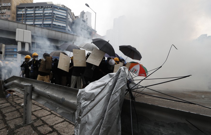 Protesters react to tear gas during a face off with riot police at Yuen Long district in Hong Kong Saturday, July 27, 2019. Police in Hong Kong shot tear gas at protesters who defied authorities&#039; ...