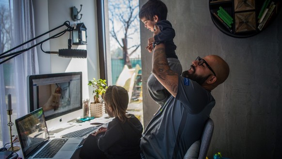 epa08348810 Hungarian DJ Lotfi Begi (R) and his children chat with one of the grandparents via Skype during their self-isolation at their home in Torokbalint, Hungary, 07 April 2020. Due to the corona ...