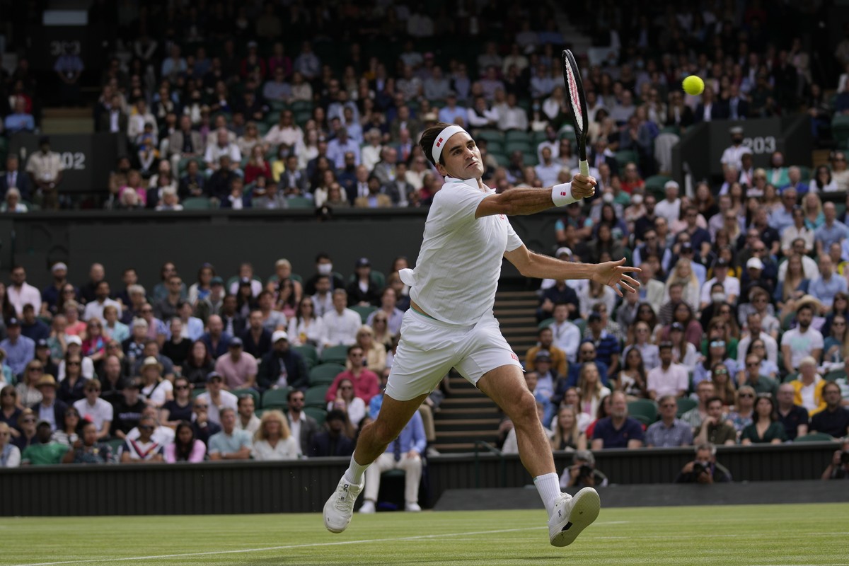 Switzerland's Roger Federer plays a return to Poland's Hubert Hurkacz during the men's singles quarterfinals match on day nine of the Wimbledon Tennis Championships in London, Wednesday ...