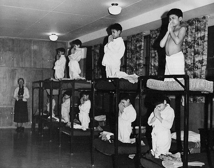 Jungen in ihrem Schlafsaal beten vor dem Zubettgehen, Bishop Horden Memorial School, Moose Factory, Provinz Ontario, 1950.