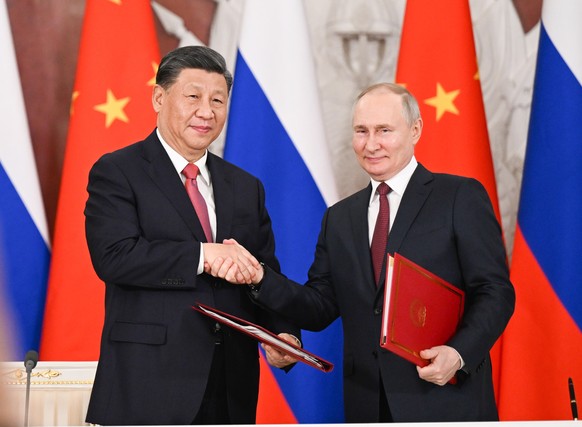 epa10536292 Chinese President Xi Jinping and Russian President Vladimir Putin shake hands after jointly signing a Joint Statement of the People&#039;s Republic of China and the Russian Federation on & ...