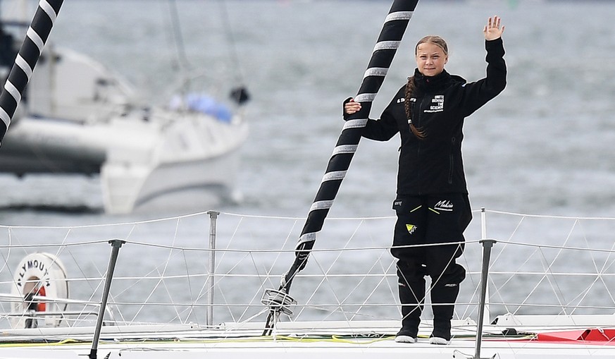 epa07773268 Swedish activist Greta waves to well-wishers while leaving Plymouth, Britain, 14 August 2019. Greta Thunberg is making her way from Plymouth to New York aboard the Malizia II to attend the ...