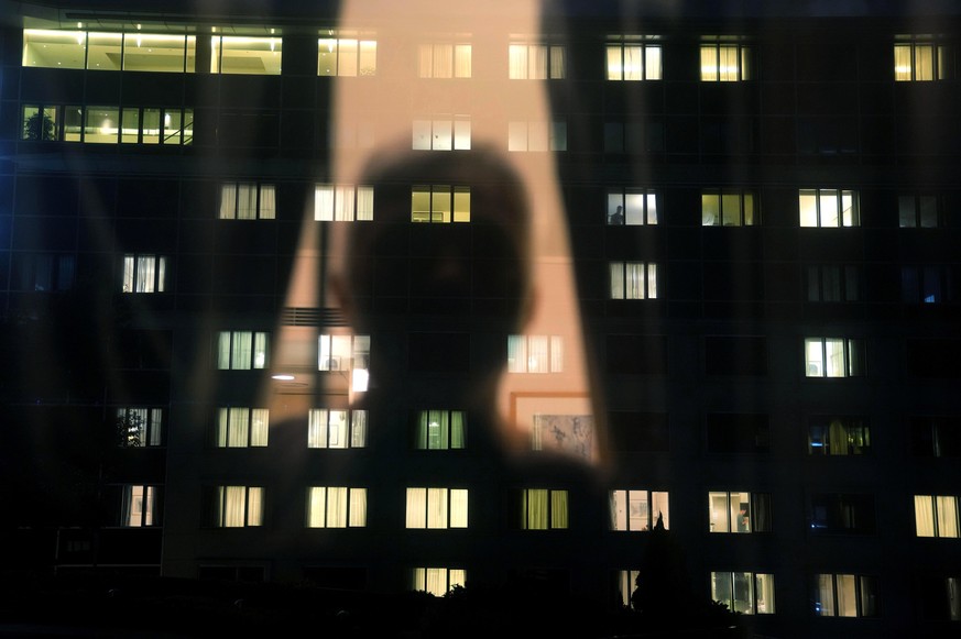 Associated Press photographer Kin Cheung is silhouetted inside an isolation hotel in Hong Kong, Friday, Aug. 13, 2021. (AP Photo/Kin Cheung)