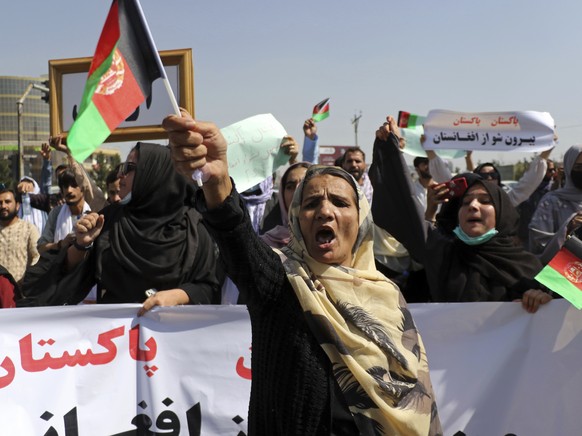 Afghan women shout slogans and wave Afghan national flags during an anti-Pakistan demonstration, near the Pakistan embassy in Kabul, Afghanistan, Tuesday, Sept. 7, 2021. Sign in Persian at right reads ...