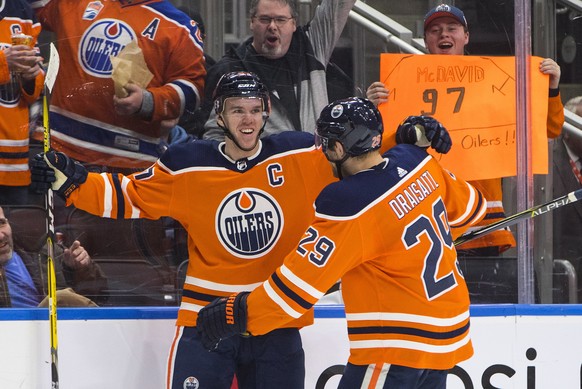 Edmonton Oilers' Connor McDavid (97) and Leon Draisaitl (29) celebrate a goal against the Tampa Bay Lightning during second period NHL hockey action in Edmonton, Alberta, Monday, Feb. 5, 2018. (J ...