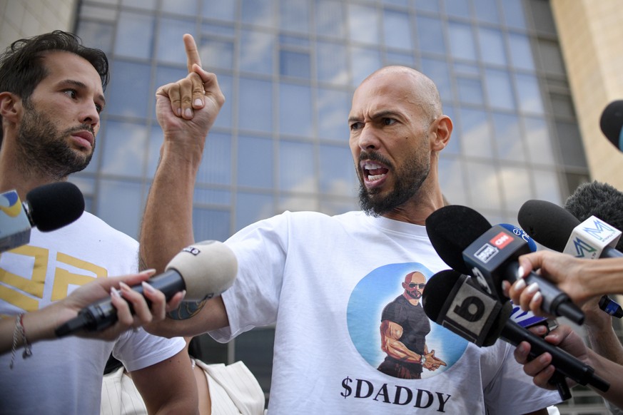 Andrew Tate speaks to media, next to his brother Tristan, left, outside the Bucharest Tribunal after being placed under house arrest, in Bucharest, Romania, Thursday, Aug. 22, 2024. A court in Romania ...